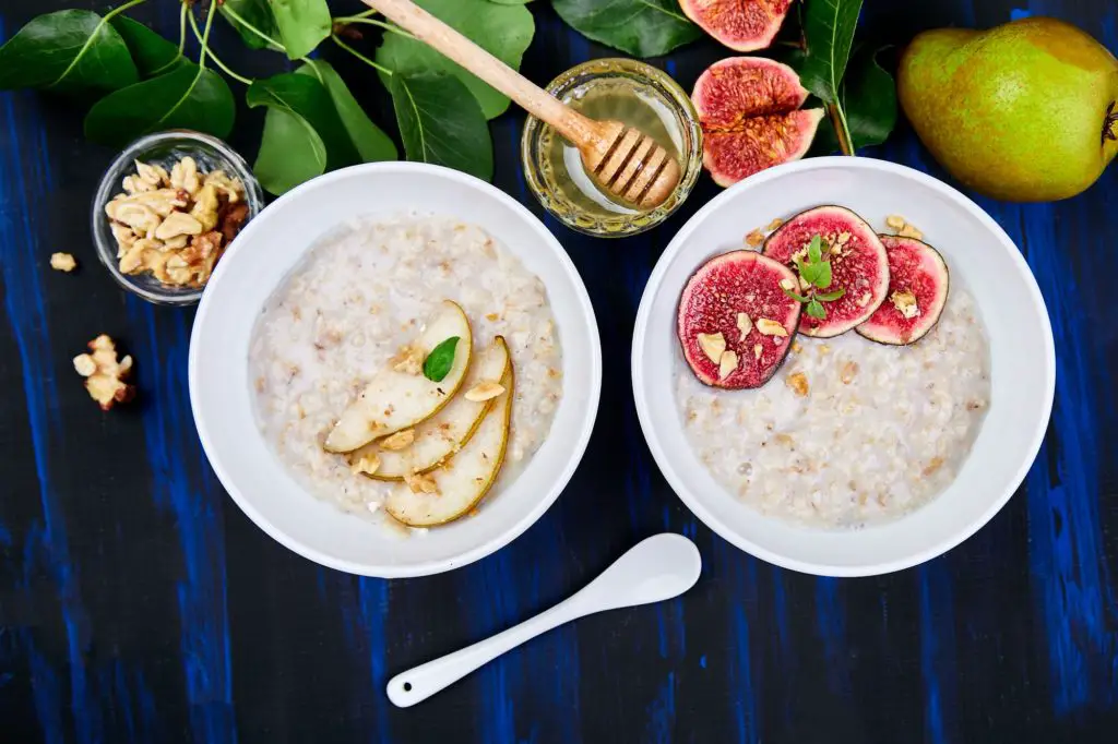 A bowl of porridge with pears slices and walnuts and porridge with figs