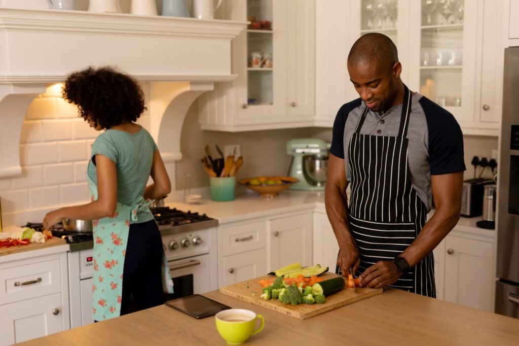 Happy young couple cooking and wearing apron in the kitchen