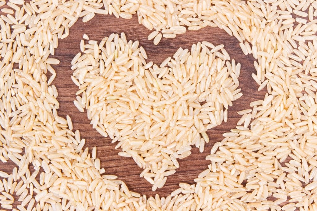 Heart shaped brown rice on rustic board