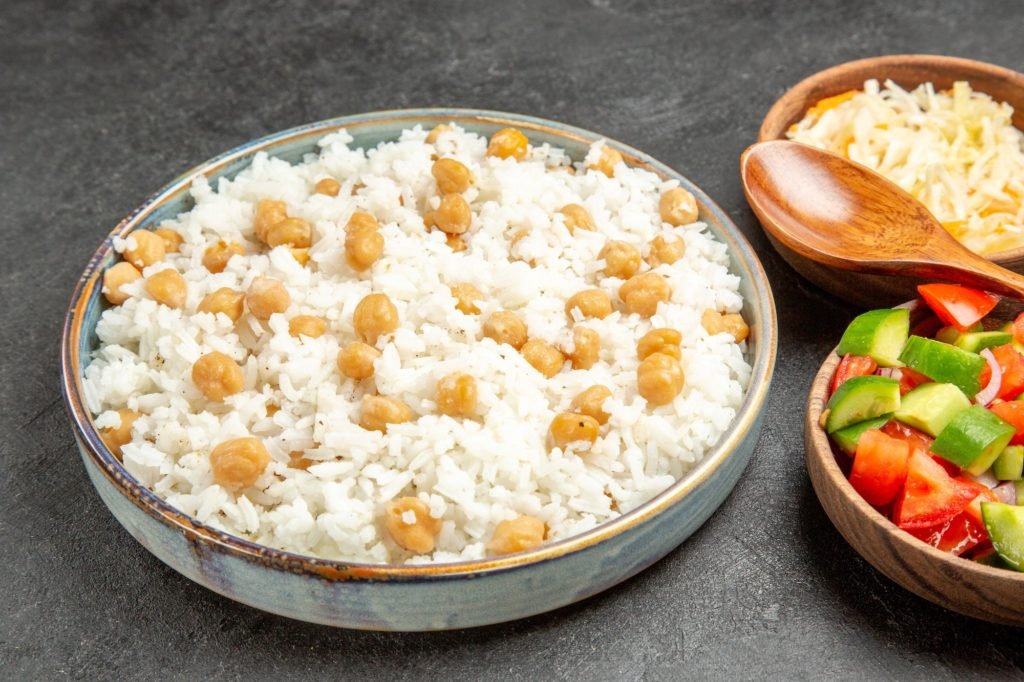 Top view of seasoned split peas and rice sauerkraut and salad on dark background