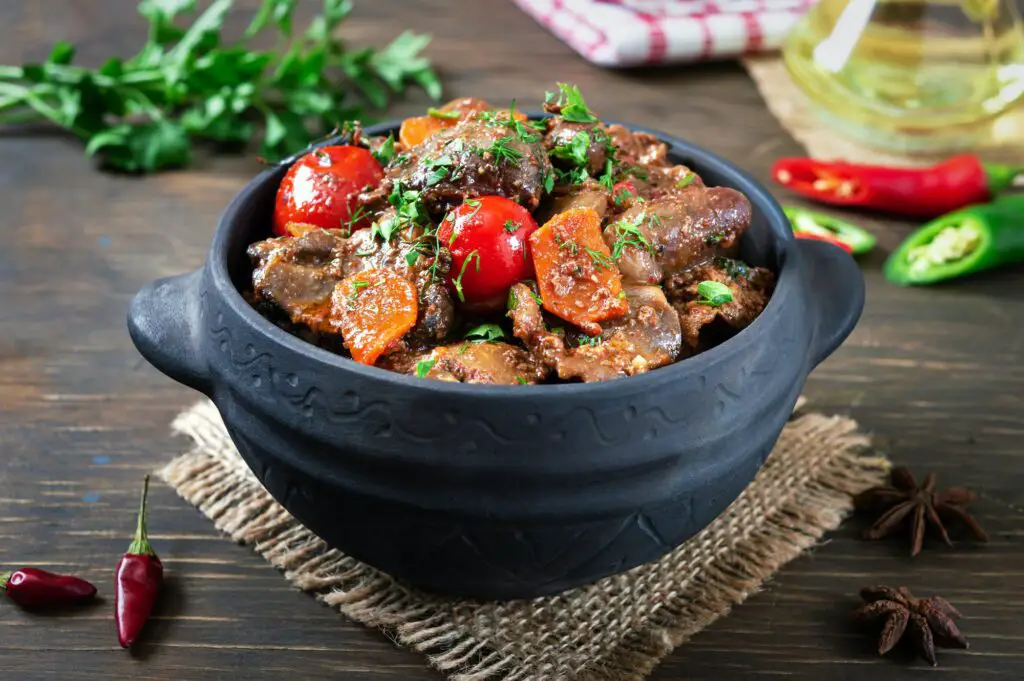 Roast turkey liver with vegetables in a pot. Delicious dietary meal. Rustic style.