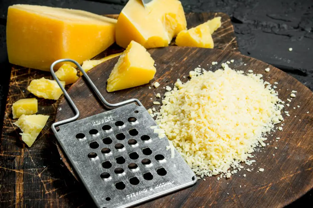 Grated Parmesan cheese on a wooden Board.