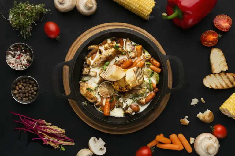 Chicken and vegetables stewed in pot on black background