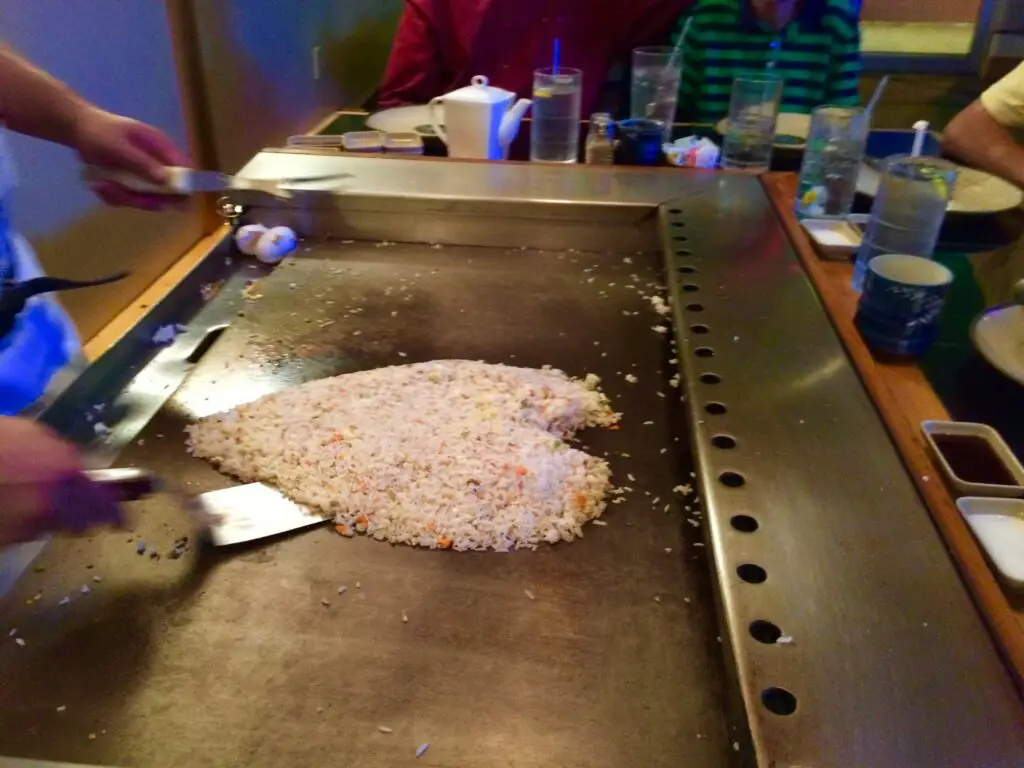 Chef cooking at a Hibachi grill making a heart with the rice to put some fun while cooking.